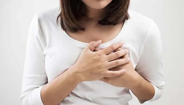 A representational image of a woman clutching at her chest because of pain